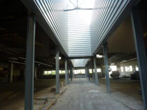 création de patios par une ouverture sur toiture amiante ciment, mise en place d'une charpente, pour un bardage double peau en partie haute, et baies vitrées en partie basse