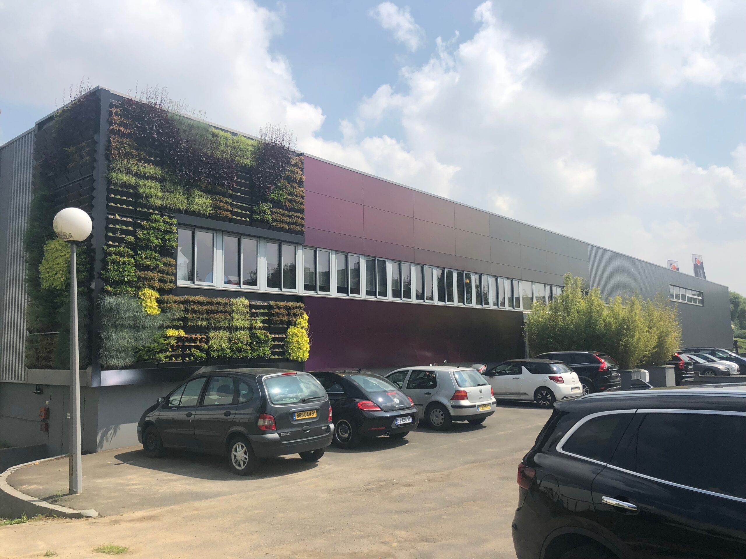 Façade rénovée en bardage végétalisé et panneaux caméléons du siège CPV Plus à Morangis