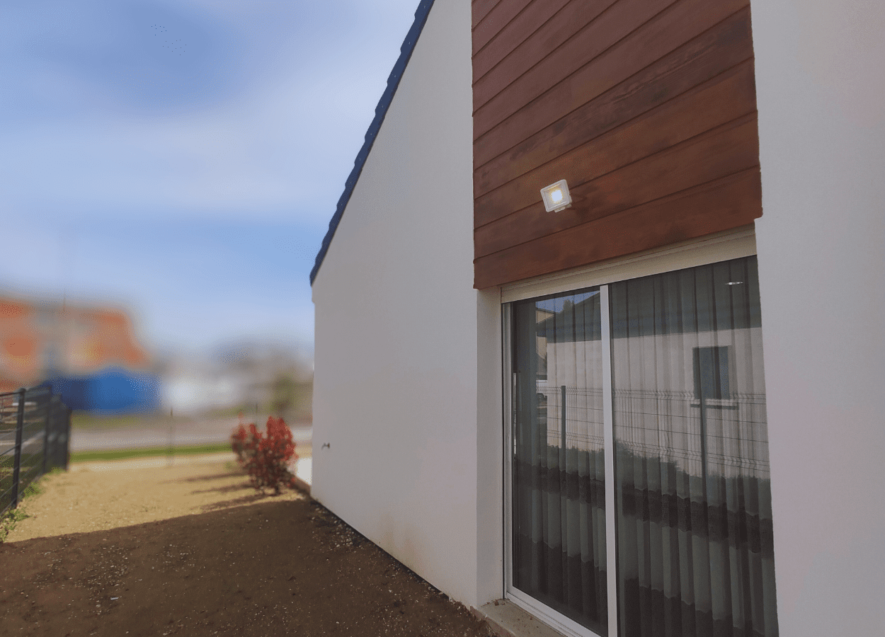 Pose de panneaux isolants et enduit sur la façade d’un pavillon dans le cadre d’une isolation thermique par l’extérieur (ITE).