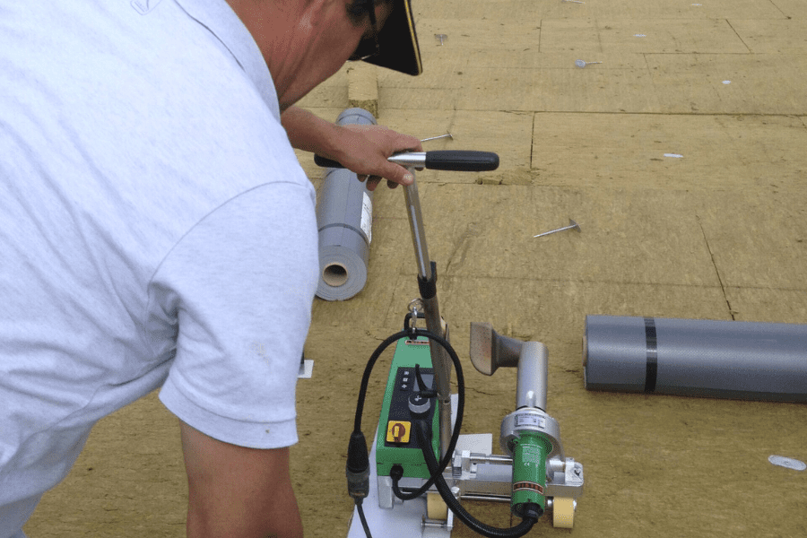 Travaux de désamiantage réalisés par des opérateurs en combinaison rouge dans une zone confinée